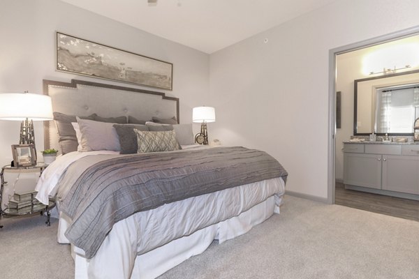 Cozy bedroom with modern decor at The Lodges on English Station Rd Apartments, featuring elegant design and ample natural light