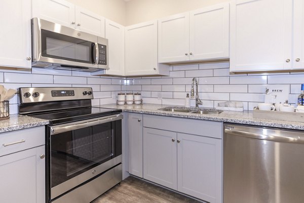 Modern kitchen with stainless steel appliances at The Lodges on English Station Rd Apartments
