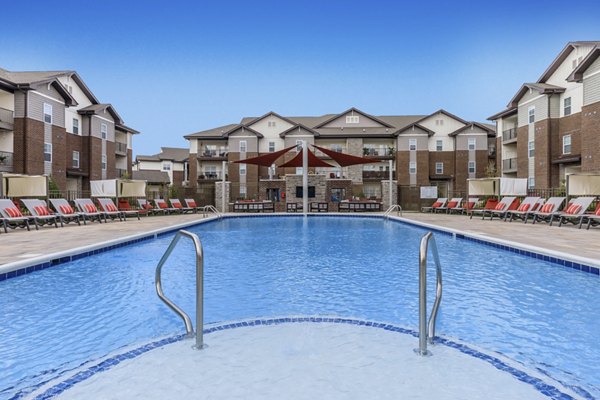 Inviting pool with surrounding lounge chairs at The Lodges on English Station Rd Apartments