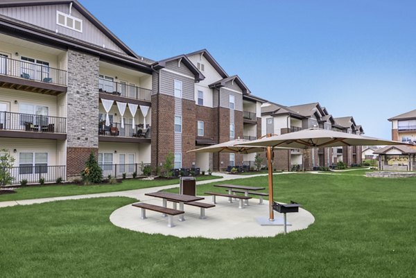 Lush courtyard garden with seating at The Lodges on English Station Rd Apartments
