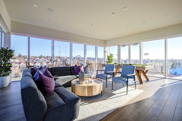 Modern clubhouse with communal seating and entertainment spaces at Connection on Broadway Apartments, ideal for social gatherings