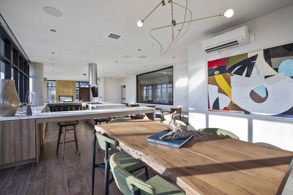 Clubhouse with modern lounge seating and a fireplace at Connection on Broadway Apartments