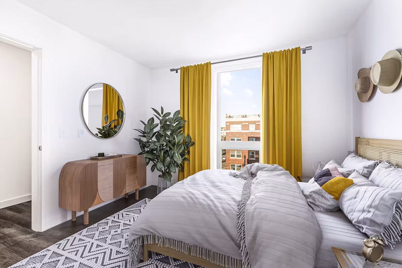 Spacious bedroom with modern furnishings at Connection on Broadway Apartments, offering luxury living in a vibrant urban setting