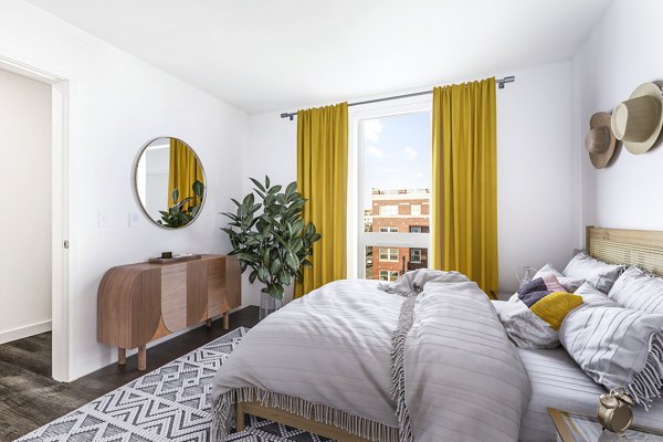Spacious bedroom with modern furnishings at Connection on Broadway Apartments, offering luxury living in a vibrant urban setting