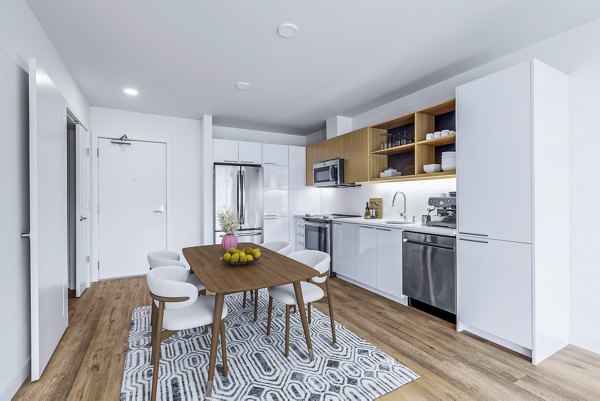 Modern kitchen with stainless steel appliances at Connection on Broadway Apartments