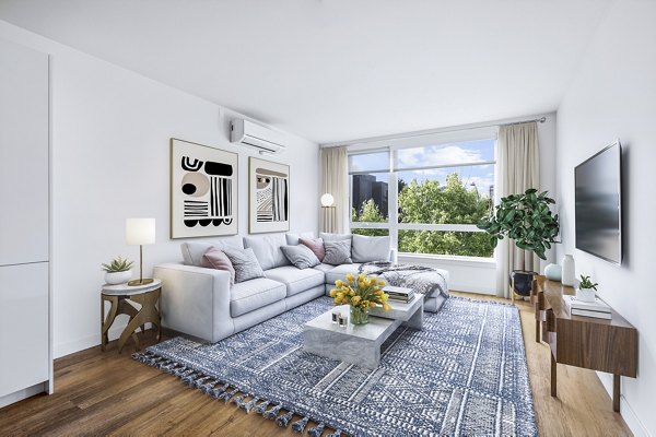 Spacious living room with modern decor at Connection on Broadway Apartments, enhancing luxury living in urban settings