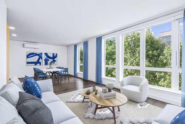 Living room featuring cozy seating and modern decor at Connection on Broadway Apartments
