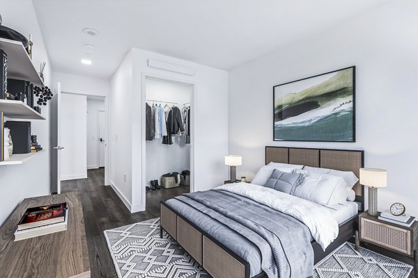 Bedroom featuring modern decor and ample natural light at Connection on Broadway Apartments