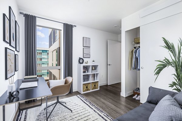 Multi-functional bedroom and home office with ample natural light at Connection on Broadway Apartments