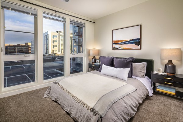 Bedroom with modern furnishings and natural light at Revel Apartments