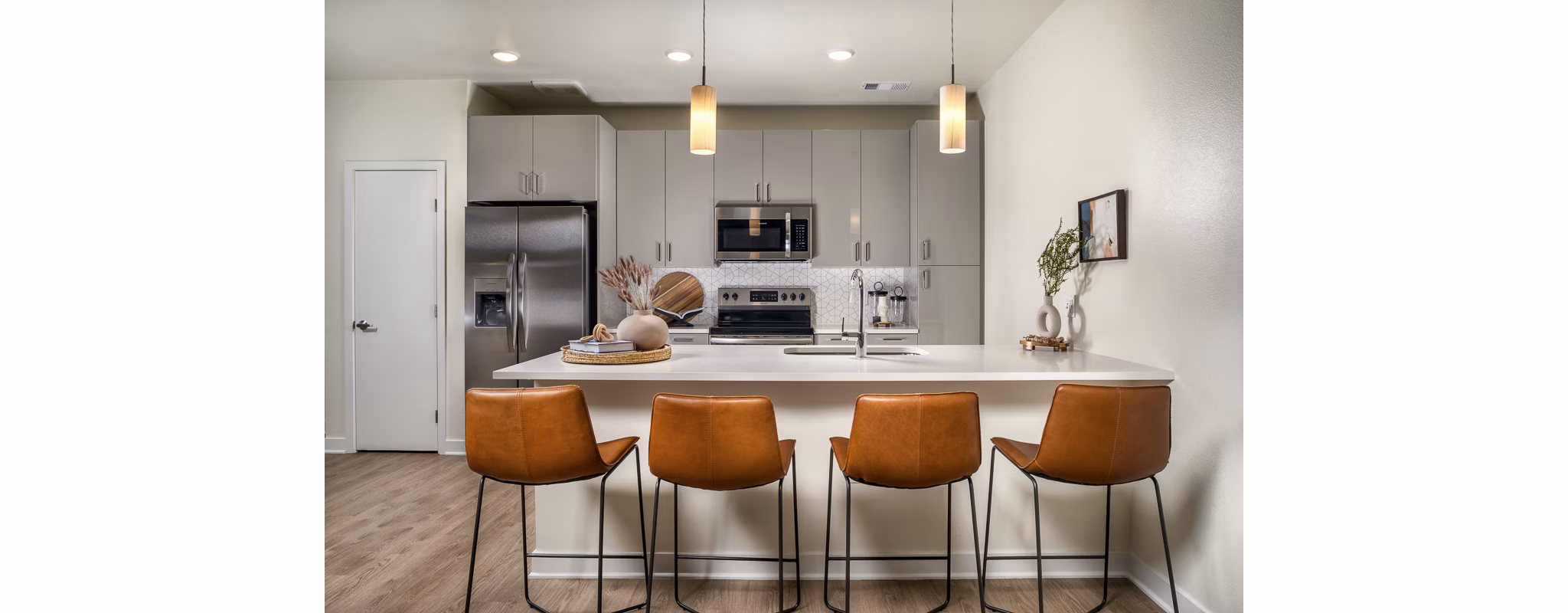 Modern kitchen featuring stainless steel appliances and quartz countertops in Revel Apartments