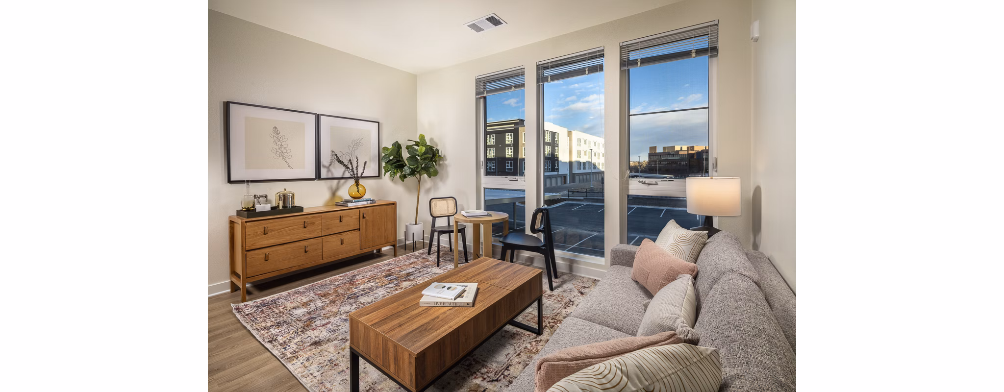 Spacious living room with modern decor and large windows at Revel Apartments