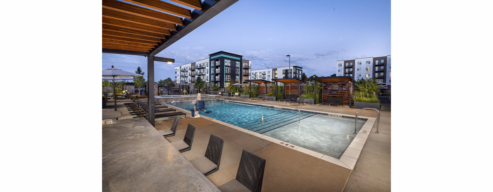 Revel Apartments: Luxurious pool area with modern lounge chairs in a vibrant community setting