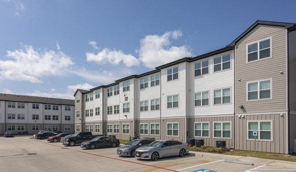 Luxury apartment building with modern architecture and a parking lot in front in upscale community