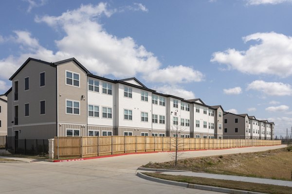 Modern multi-story luxury apartments with fenced perimeter in upscale neighborhood