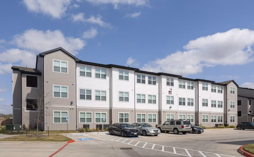 Modern luxury apartment building with parking lot in front