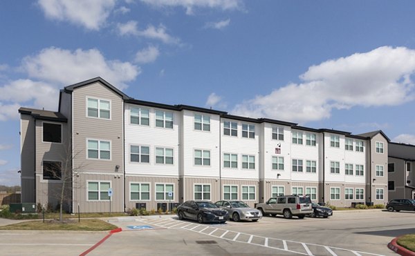 Modern luxury apartment building with parking lot in front