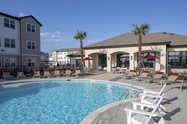 Resort-style swimming pool with lounge chairs and umbrellas in luxury apartments