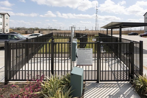 Fenced dog park area with rules sign at luxury apartments