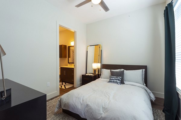 Contemporary bedroom with chic furnishings at Millennium Music Row Apartments in Nashville