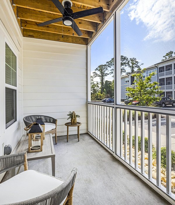 Cozy patio with modern furniture overlooking lush landscape at Eventide Apartments