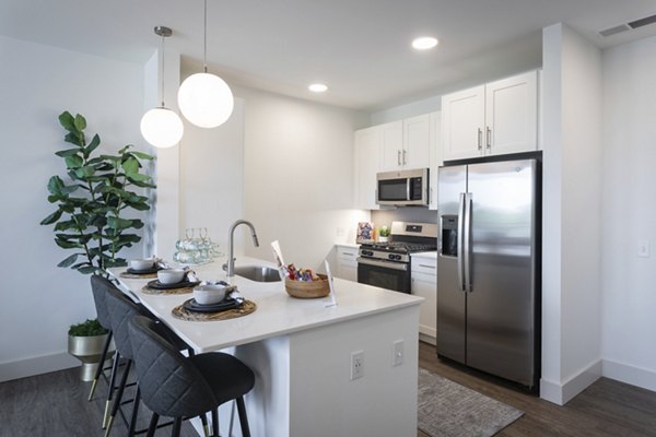 Modern kitchen featuring stainless steel appliances and granite countertops at Everleigh Vernon Hills Apartments