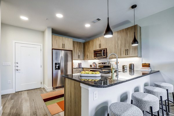 Modern kitchen with sleek countertops and stainless steel appliances at Encore Motif Apartments
