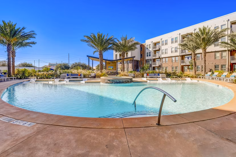 Sparkling outdoor pool with sun loungers at Encore Motif Apartments