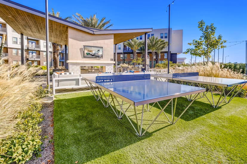 Outdoor recreational area with lush greenery and seating at Encore Motif Apartments â€“ ideal for relaxation and socializing in a luxury setting