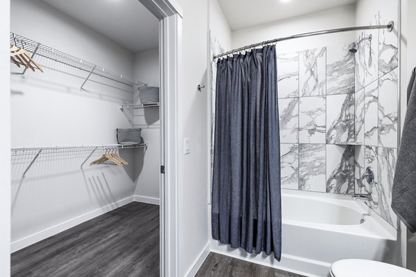 Modern bathroom with elegant vanity and large mirror at Prose Manor Apartments