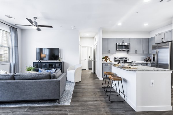 Living room with modern decor and large windows at Prose Manor Apartments, luxury living in a stylish community setting