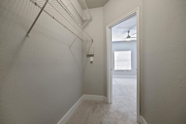 Siena Apartments: Walk-in closet with custom shelving in a luxury apartment setting