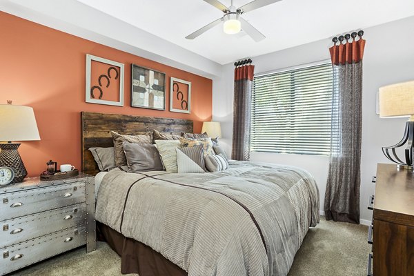 Cozy bedroom with modern decor and ample natural light at 601 PAX Apartments, a luxury Greystar property