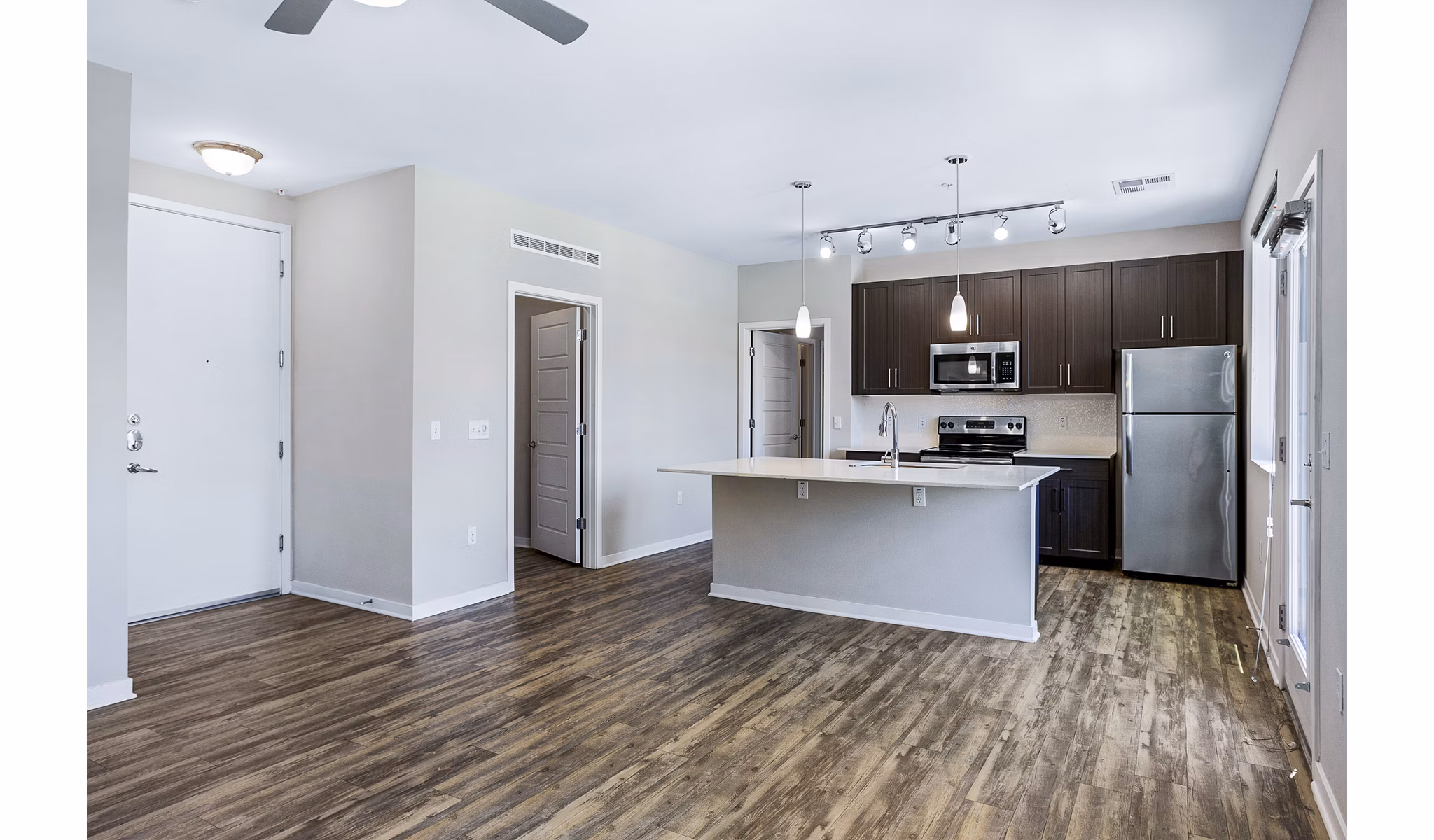 Modern living room with hardwood floors and large windows at 601 PAX Apartments, luxury living in the heart of the city