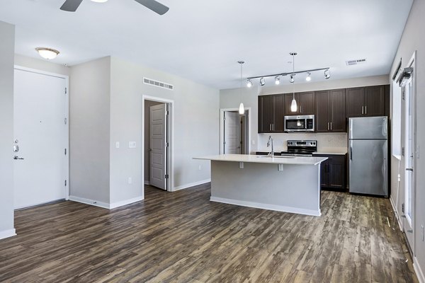 Modern living room with hardwood floors and large windows at 601 PAX Apartments, luxury living in the heart of the city