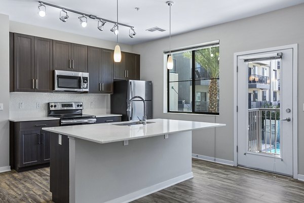 Kitchen featuring modern appliances and sleek countertops at 601 PAX Apartments, a luxury residence in an urban setting