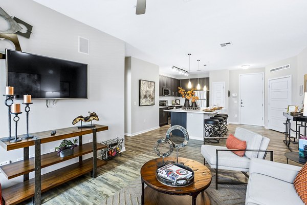 Spacious living room with modern furnishings and large windows at 601 PAX Apartments, a Greystar luxury property in urban setting