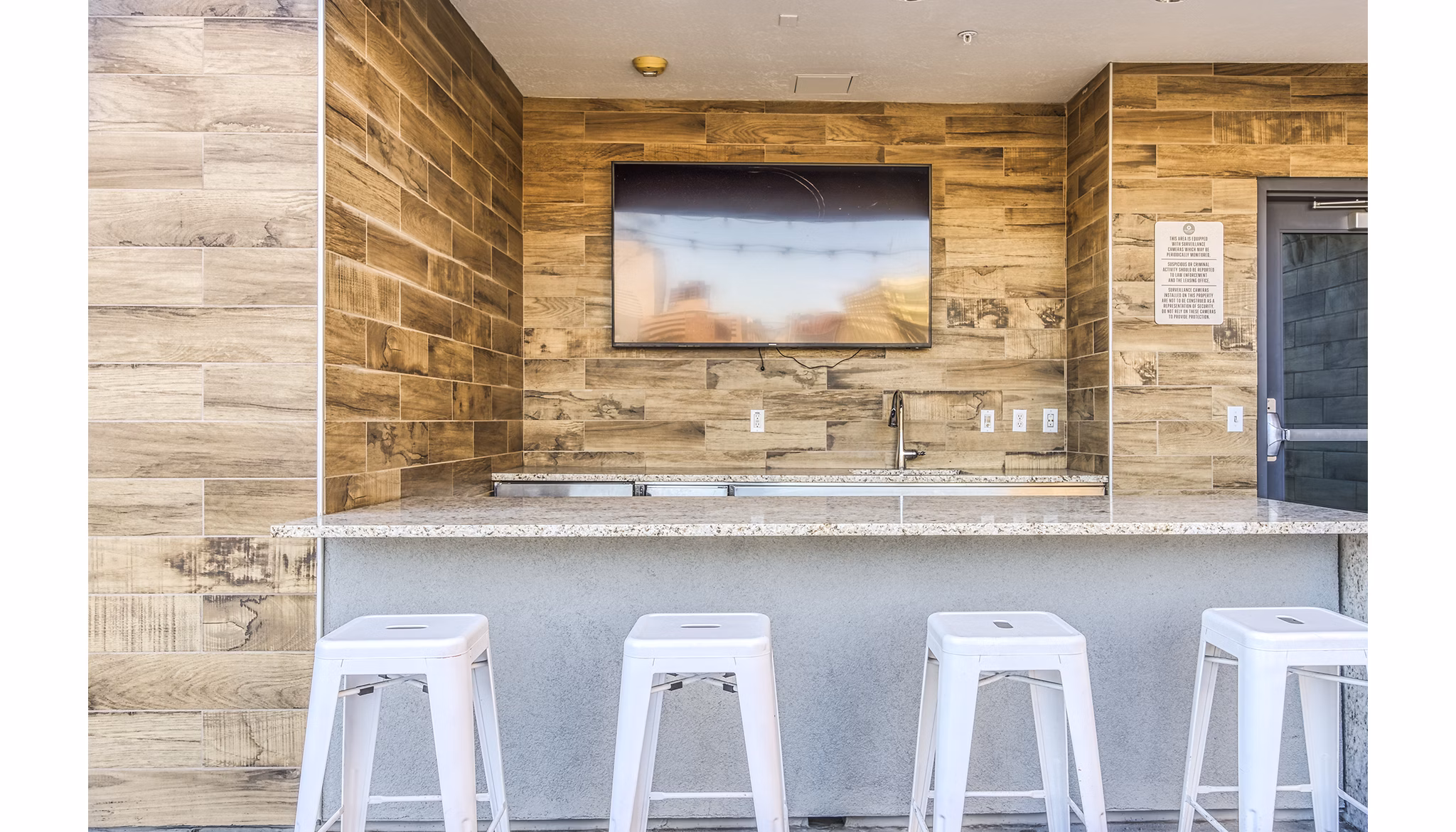 Clubhouse balcony bar area with sleek countertops and city views at 601 PAX Apartments, luxury living in urban setting