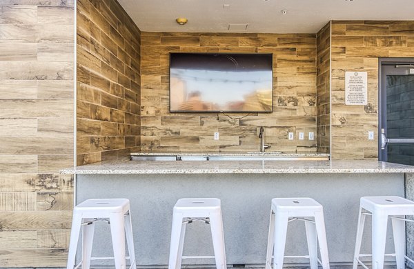 Clubhouse balcony bar area with sleek countertops and city views at 601 PAX Apartments, luxury living in urban setting