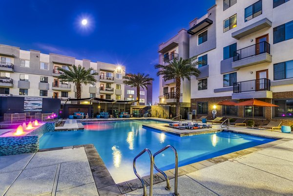 Poolside luxury at 601 PAX Apartments: Modern swimming pool surrounded by lush landscaping and upscale lounge chairs