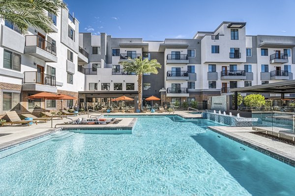 Luxurious pool at 601 PAX Apartments, a Greystar community, featuring comfortable lounge chairs and lush greenery for relaxation