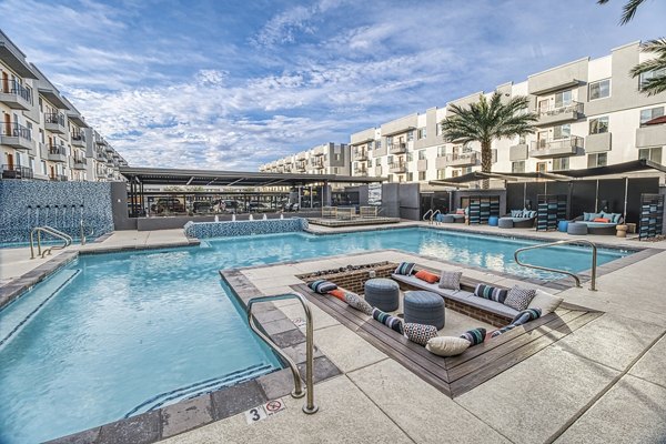 Elegant nighttime view of a sparkling pool at 601 PAX Apartments, offering a luxurious retreat in a premier urban location