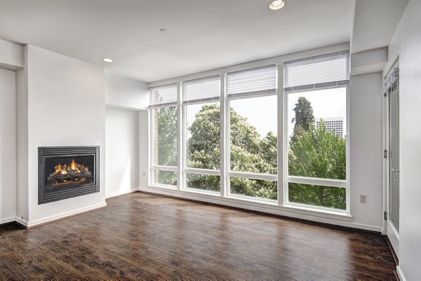 Spacious living room with modern decor and large windows in Hanna Heights Apartments, luxury living by Greystar