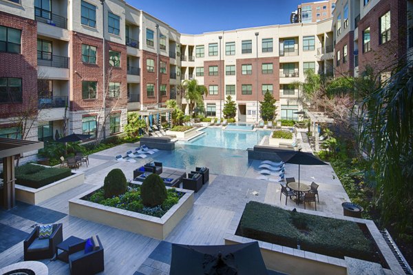 Outdoor seating area with lush greenery at Millennium High Street Apartments, ideal for recreation and relaxation