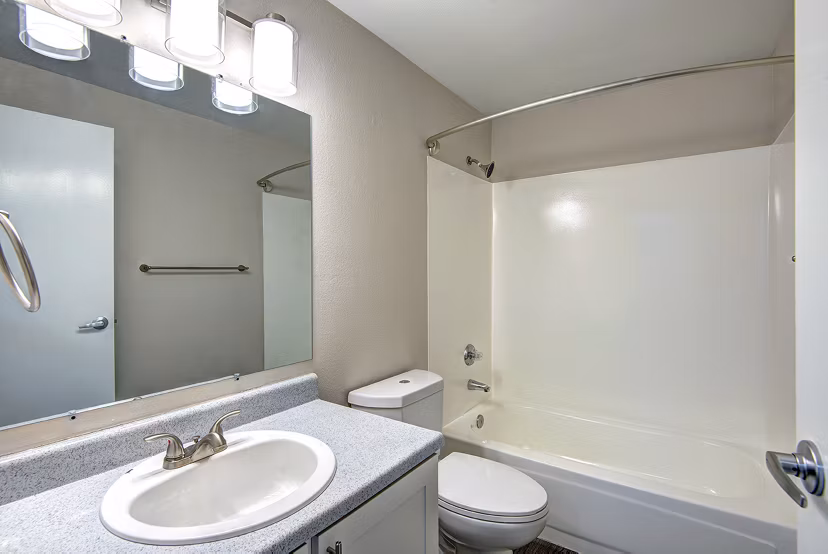 Luxurious bathroom with a modern vanity and glass shower at The Becket Apartments