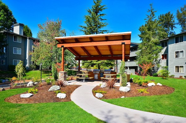 Outdoor grill area with modern seating at The Becket Apartments