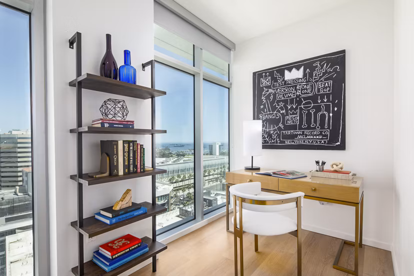 Bedroom with stylish home office at 200 West Ocean Apartments featuring a sleek desk and comfortable seating