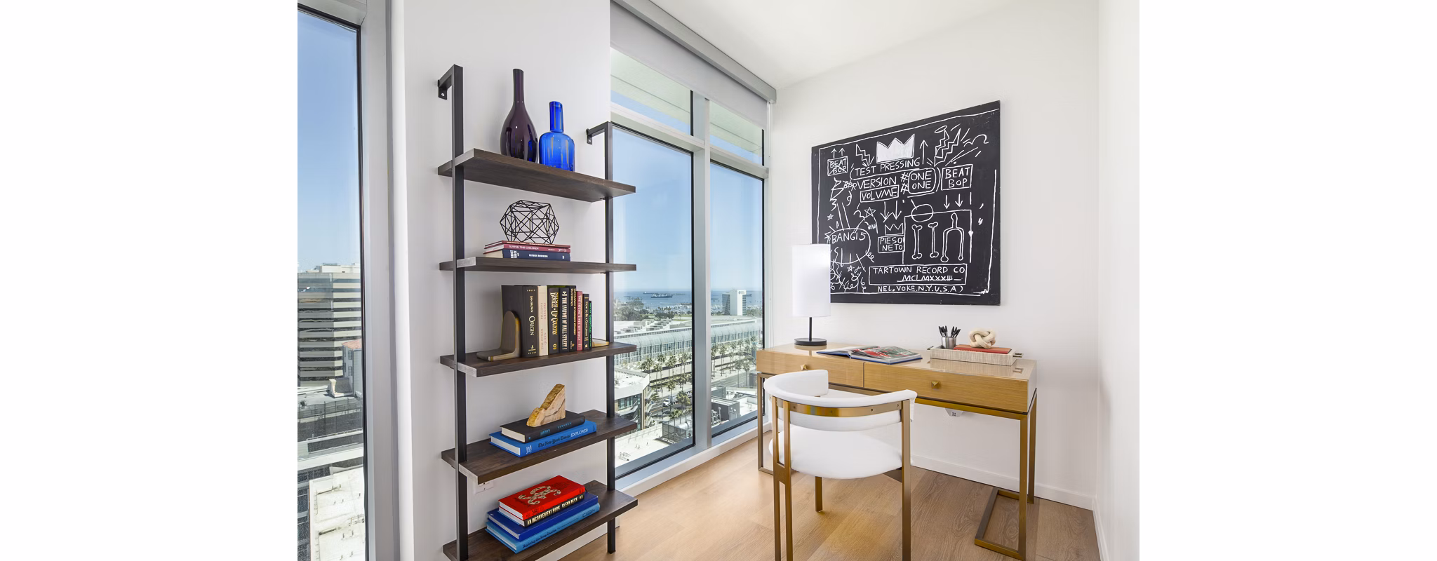 Bedroom with stylish home office at 200 West Ocean Apartments featuring a sleek desk and comfortable seating