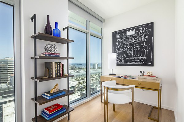 Bedroom with stylish home office at 200 West Ocean Apartments featuring a sleek desk and comfortable seating
