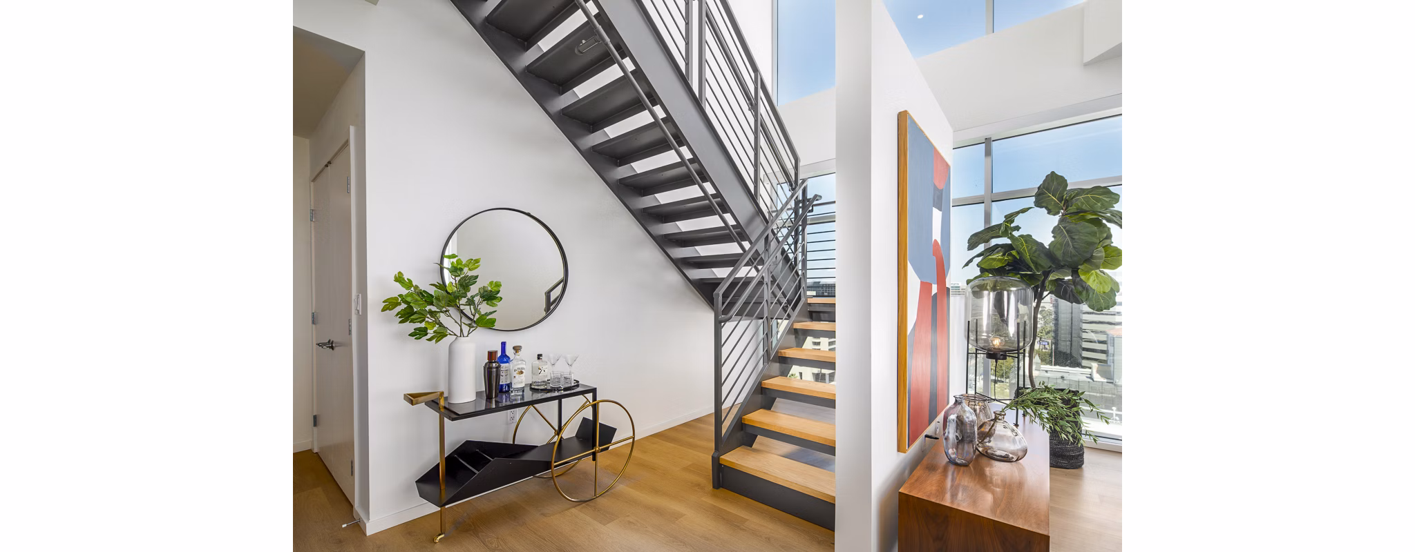 Open living room with elegant stairway at 200 West Ocean Apartments, a luxury community by Greystar